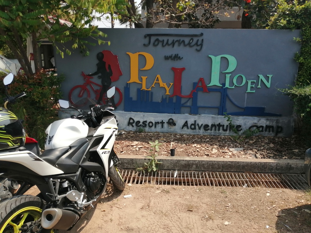 A motorcycle parked in front of a wall with graffiti Description automatically generated with medium confidence
